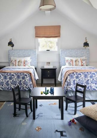 barnsäng, två enkelsängar, svarta stolar och bord med byggstenar, blommig sänggavel