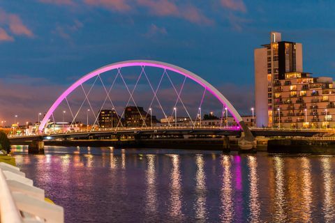 Storbritannien, Skottland, Glasgow, upplyst Clyde Arch Bridge över floden Clyde i skymningen