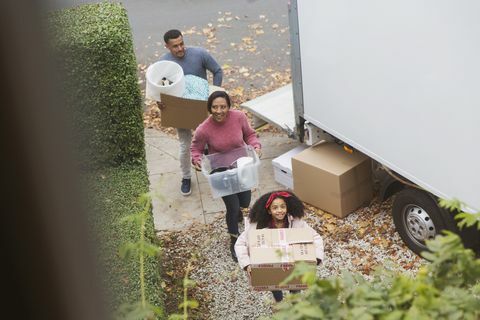Familjen flyttar in i nytt hus och bär lådor från flyttbilen