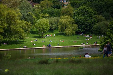 Lokalbefolkning och turister som tycker om vädret på Hampstead Heath, London