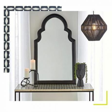 spegel som sitter på en mönstrad skänk, tillsammans med en växtkruka och ljus