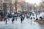 Skridskoåkare glider över Amsterdams frysta kanaler under Europas stora frysning