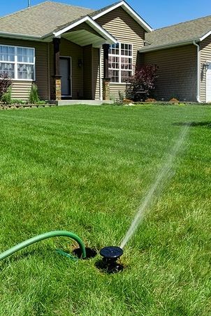 Sprinkler i marken med anslutning till trädgårdsslang