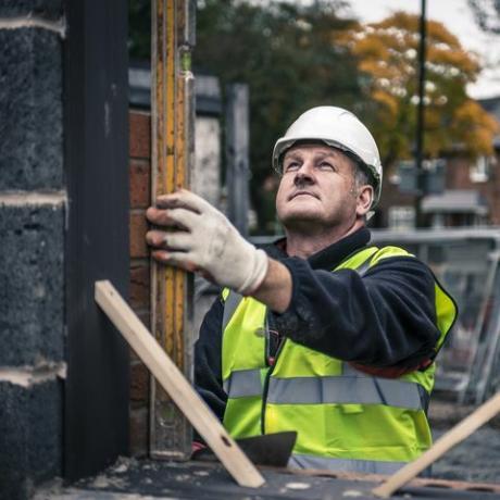 arbetare som lägger tegelstenar på byggarbetsplatsen