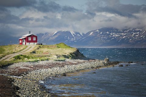 rött hus bredvid en fjord i norra Island