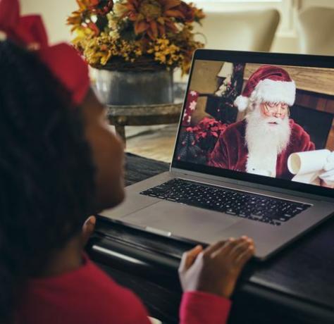 en liten flicka som pratar med jultomten på ett datorvideokonferenssamtal