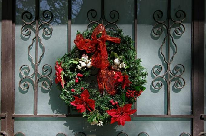 julkrans på en elegant ytterdörr i smidesjärn och frostat glas