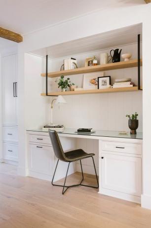 ett vitt kök med en svart stol
