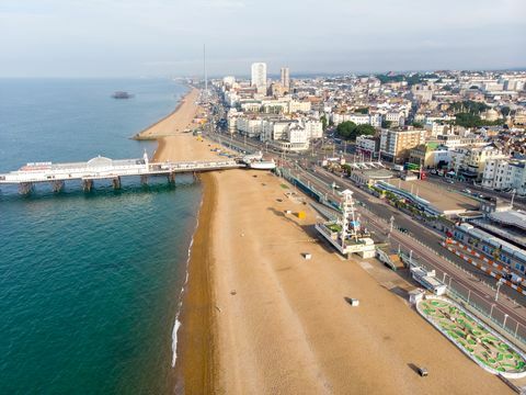 flygfoto av den berömda Brighton piren och havet ligger på södra kusten i England Storbritannien som är en del av staden Brighton och Hove, taget på en ljus solig dag som visar nöjesfältet