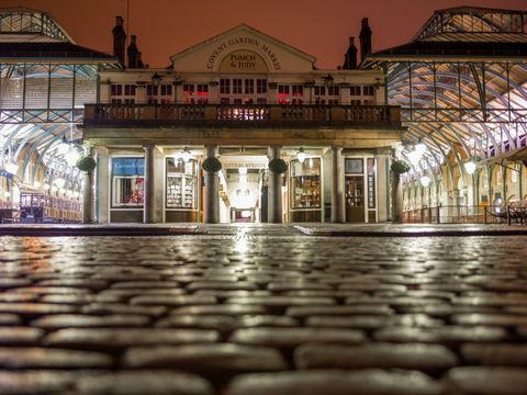 Covent Garden Piazza på natten med reflekterande ljus i kullstenen