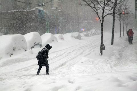 Kvinna som korsar gatan under snöstormen Jonas i Bronx