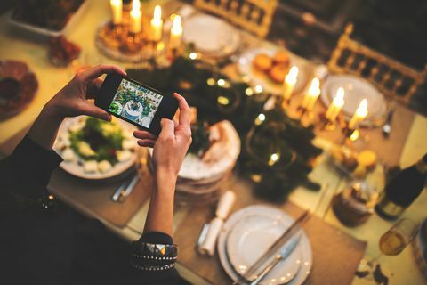 Kvinnan tar fotografi av inställningen för jultabell